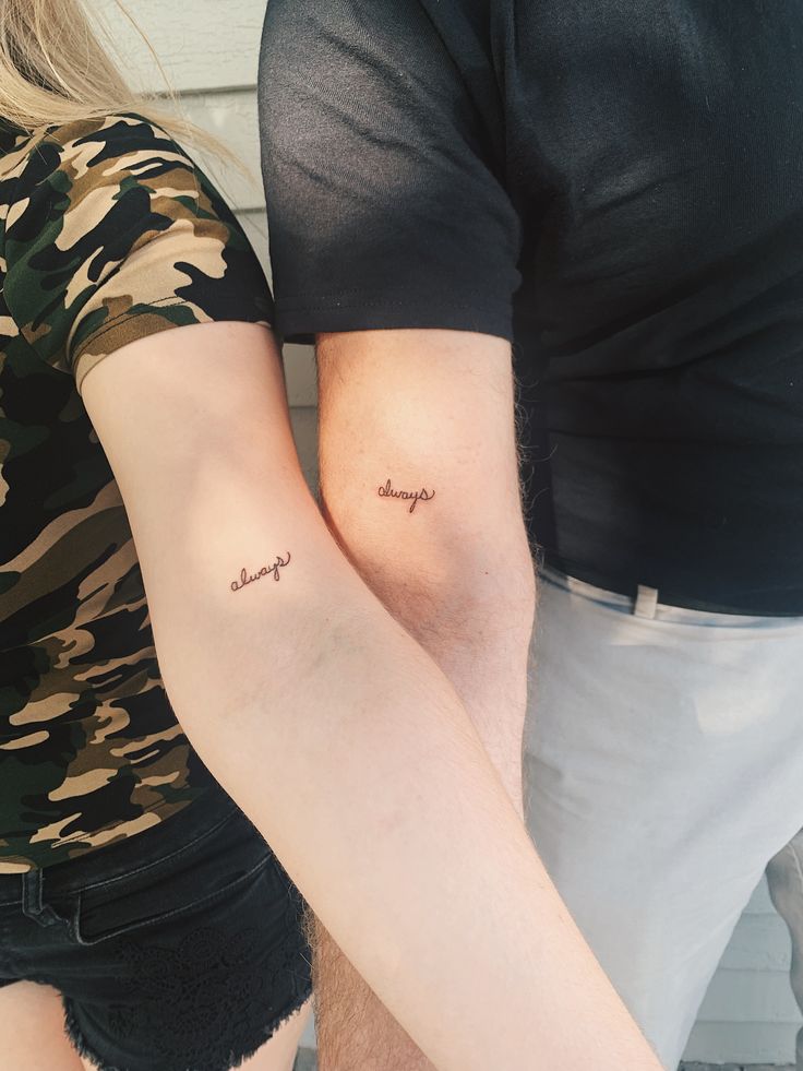 two people with tattoos on their arms and one is holding the other's arm