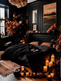 a bedroom decorated in black and orange with candles on the floor next to the bed