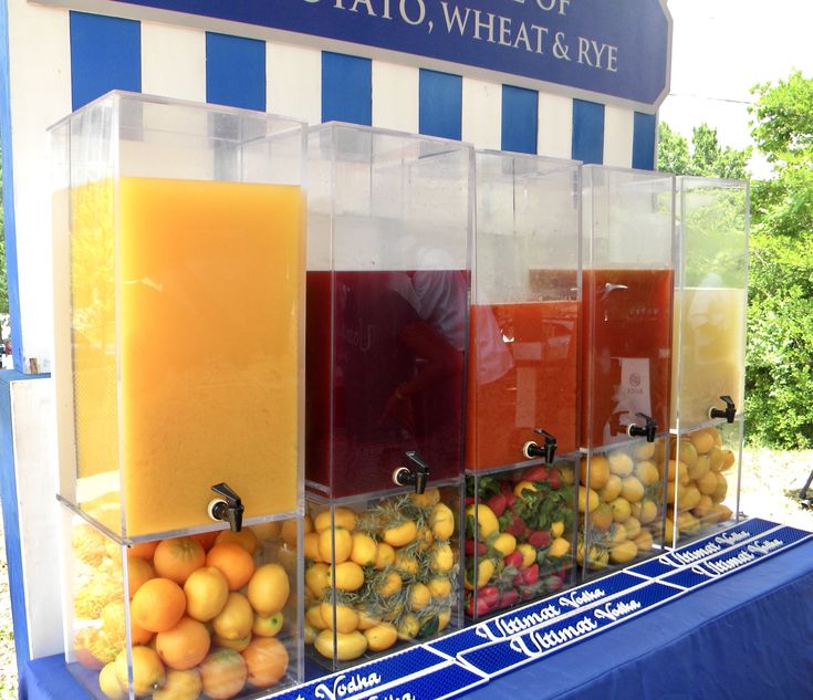 an assortment of fruits and juices on display in front of a blue table cloth