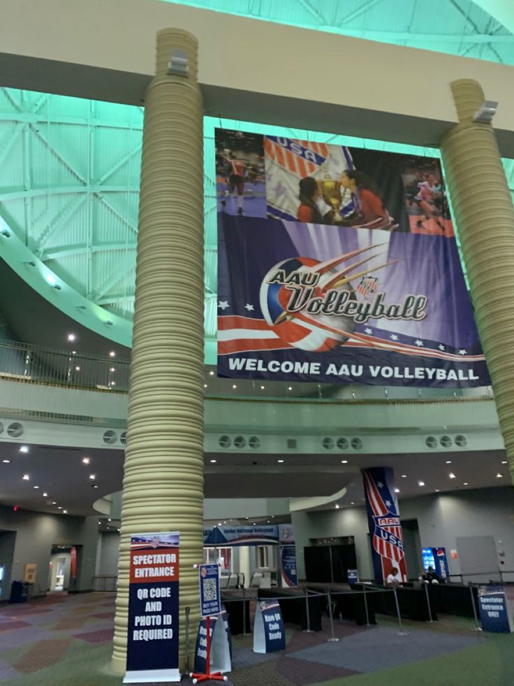 the inside of a building with two large pillars and banners on it's walls