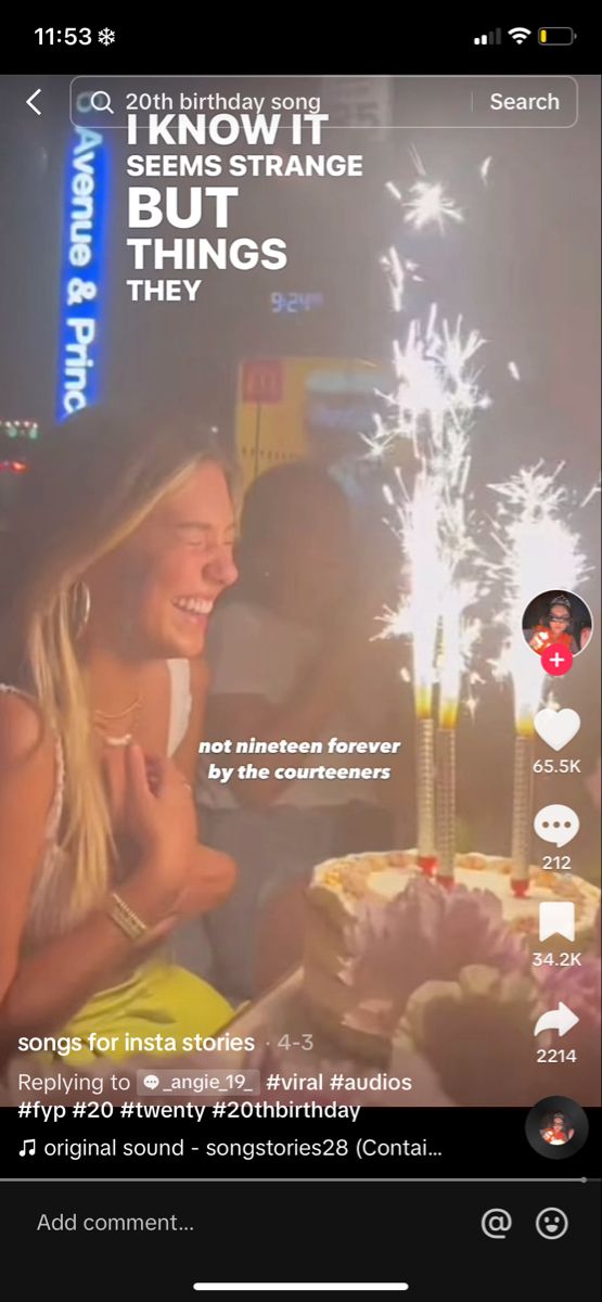 a woman sitting in front of a birthday cake with sparklers on top of it