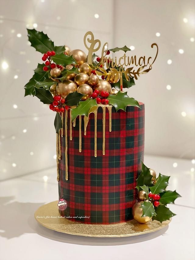 a christmas cake decorated with holly and gold decorations