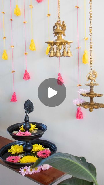 a table topped with lots of flowers next to a wall covered in tassels