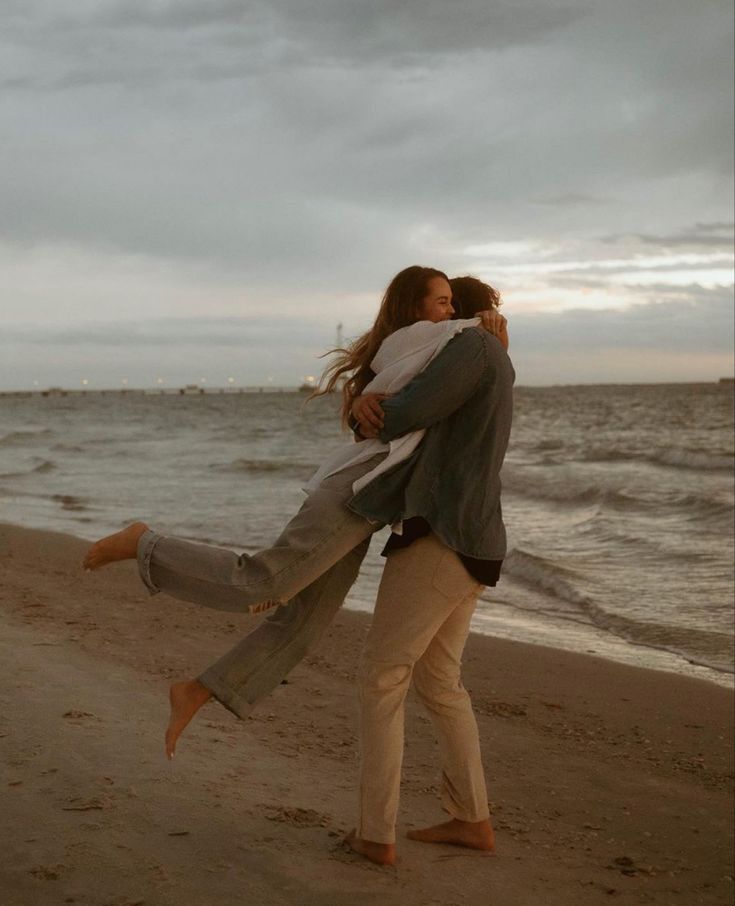 a man carrying a woman on the beach