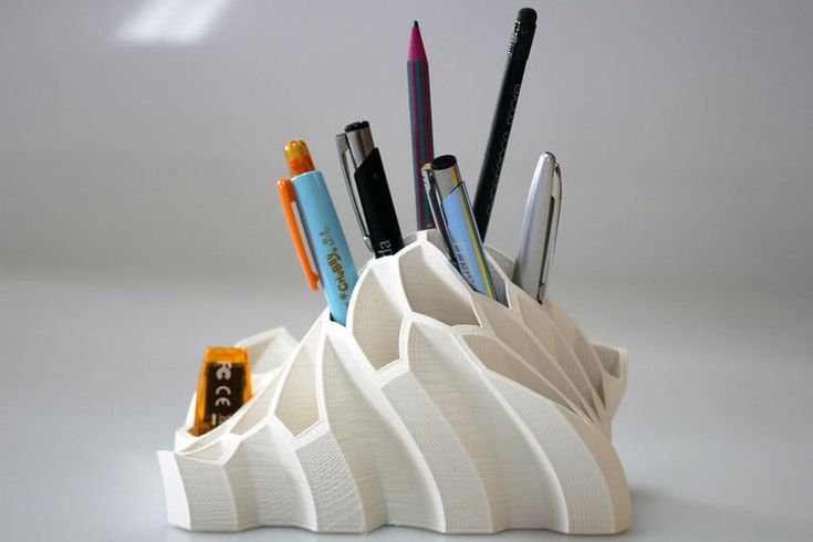 a pen holder with pens and pencils in it