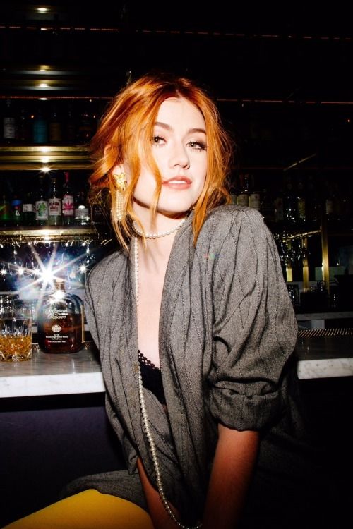 a woman with red hair sitting at a bar