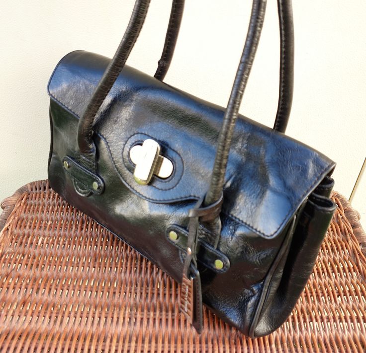 Vintage Jasper Conran black leather satchel bag.  Polished black leather with silver tone metal fittings.  Very good condition no major scuffing or damage to the leather, lining also clean and unmarked.  Handle just long enough to carry over shoulder to sit underarm or can be used on crook of arm or as carry handles. Flap with silver turnlock to close, inside lined in black with a small 90s style phone pouch and leather trmmed secure zip pocket and key holder.  Silver tone branded handbag charm Holdall Bag, Brown Leather Satchel, Jasper Conran, Leather Tote Purse, Green Purse, Black Leather Satchel, Satchel Tote Bag, Leather Satchel Bag, Handbag Charms