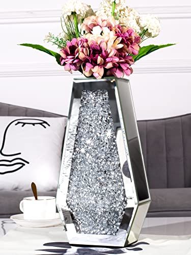 a vase filled with flowers sitting on top of a table next to a white pillow