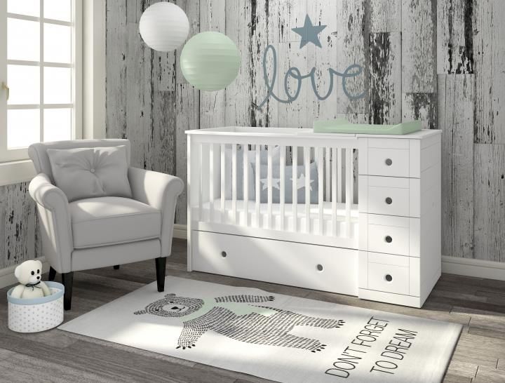 a baby's room with a crib, chair and rug