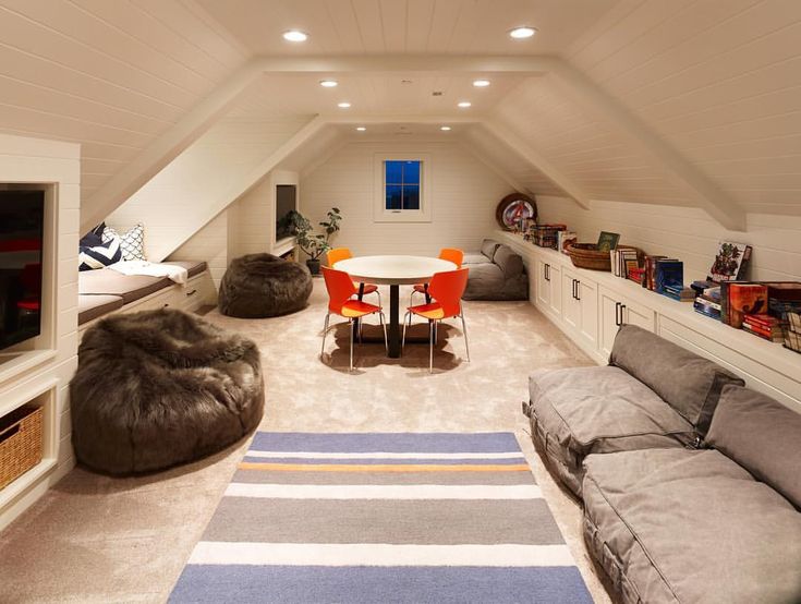 a room with couches, tables and chairs in the middle of an attic space