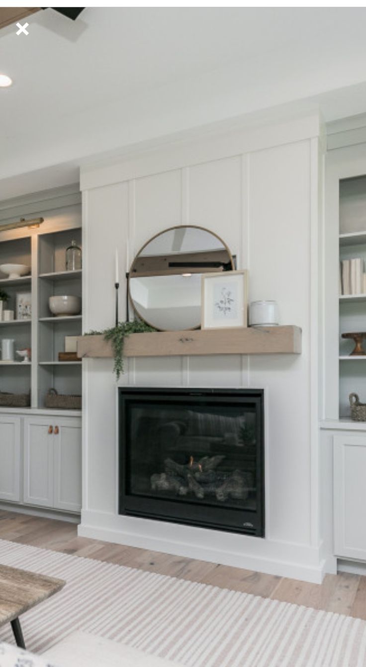 a living room filled with furniture and a fire place next to a wall mounted oven