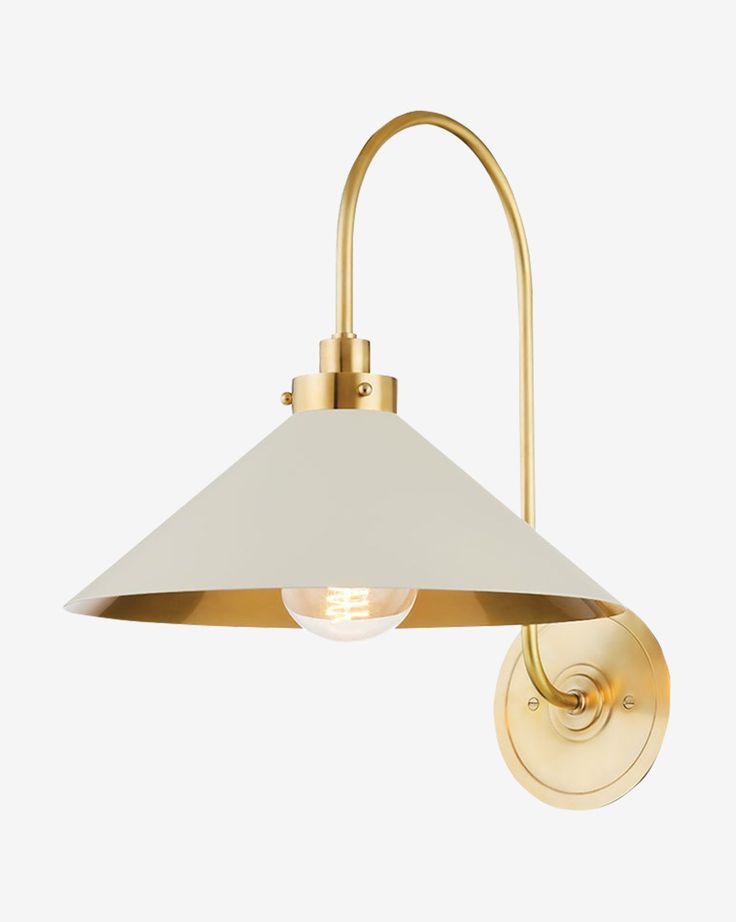 a brass wall light with a white shade on the side and a gold metal arm