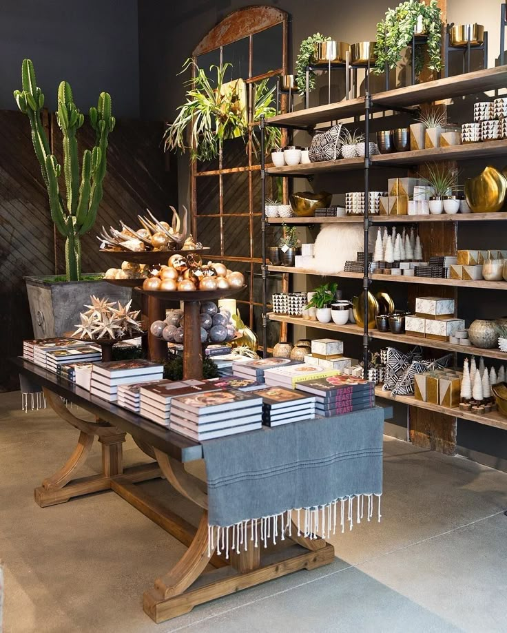 a table with some plants on it in front of shelves filled with books and other items