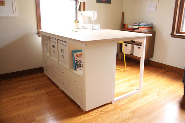 a sewing machine sits on top of a white table in the middle of a room