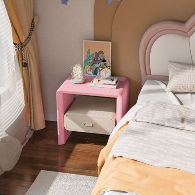 a small pink and white bed sitting next to a window