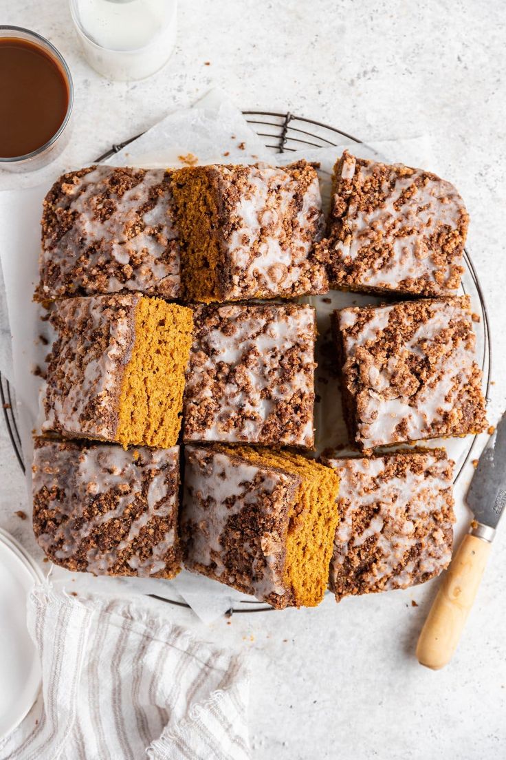 slices of pumpkin spice cake on a plate next to a cup of coffee and spoon