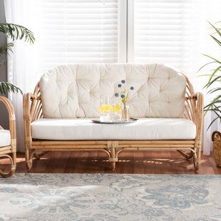 a living room with wicker furniture and white curtains on the window sill next to potted plants