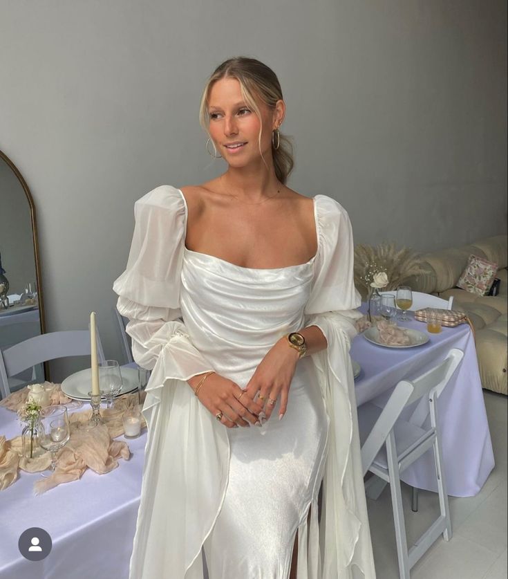 a woman in a white dress sitting at a table