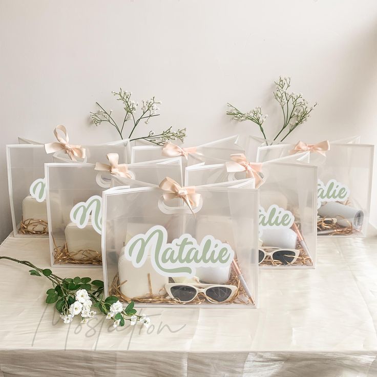 six clear bags filled with cookies and sunglasses on top of a table covered in flowers