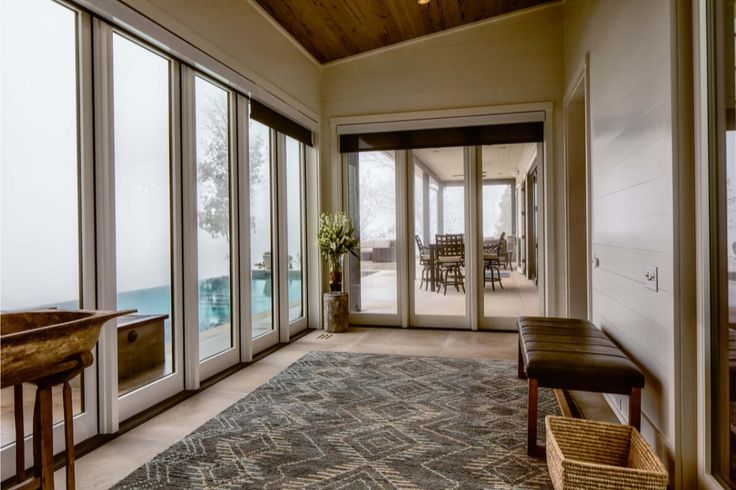 a living room filled with furniture and lots of glass doors leading to an outdoor swimming pool