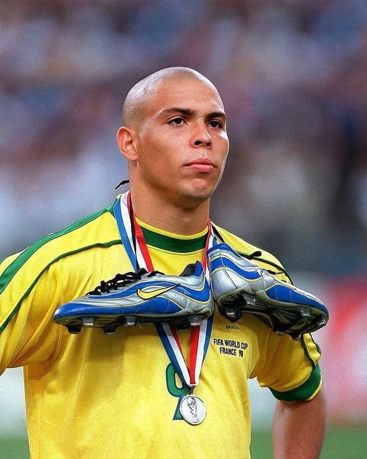 the soccer player is holding his silver medal