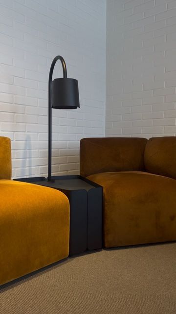 a yellow couch sitting next to a black lamp