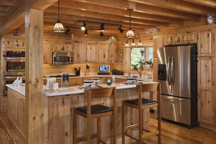 a kitchen with wooden walls and flooring next to a refrigerator