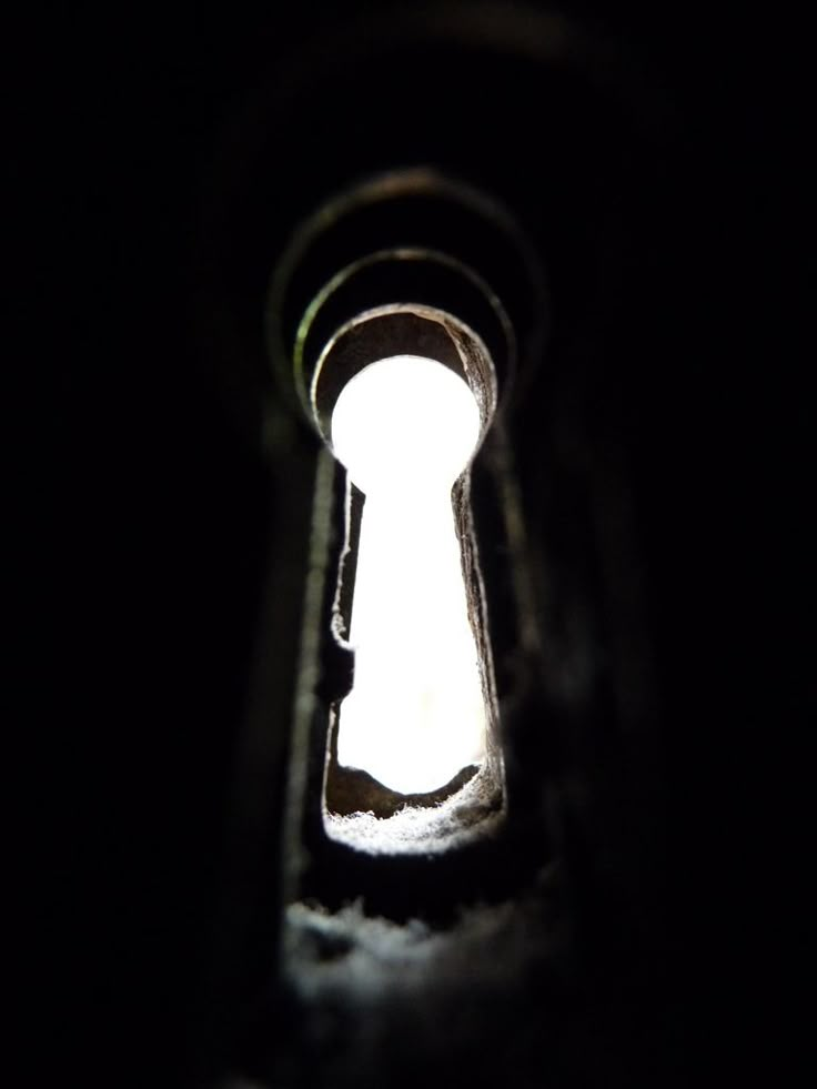 a keyhole in the dark with light coming through it