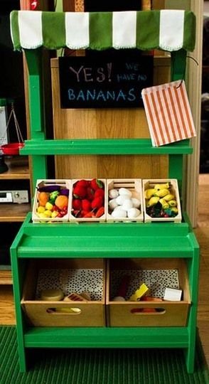 a green shelf with bins filled with fruits and vegetables on it's sides