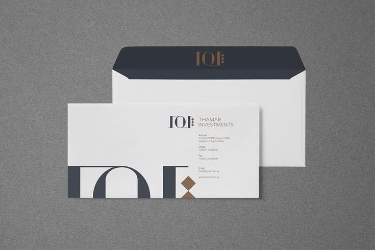 two white envelopes with black and gold foil on the front, one is open