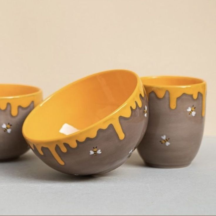 three bowls with yellow and brown designs on them