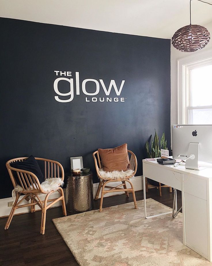 a room with two chairs and a desk in front of a wall that says the glow lounge