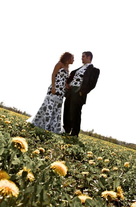 a man and woman standing in the middle of a sunflower field