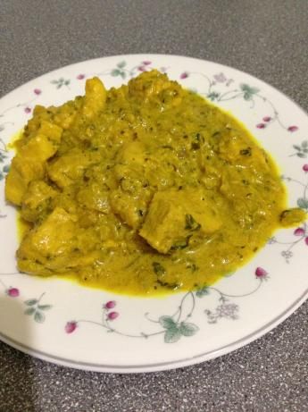 a white plate topped with meat covered in green sauce