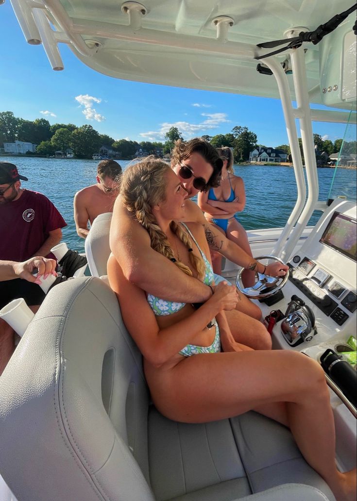 two women sitting on the back of a boat with their arms around each other as they talk