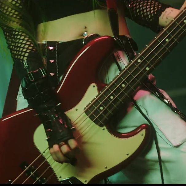 a woman in fishnet stockings holding a red guitar and wearing black gloves with her hands on her hips