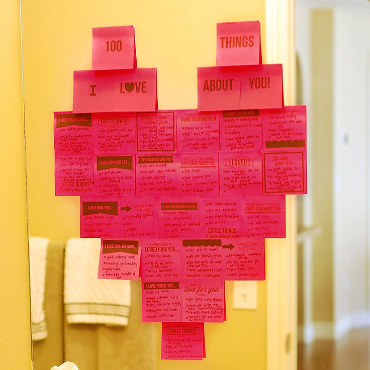 a heart shaped bulletin board hanging on the wall in front of a mirror with pink sticky notes attached to it