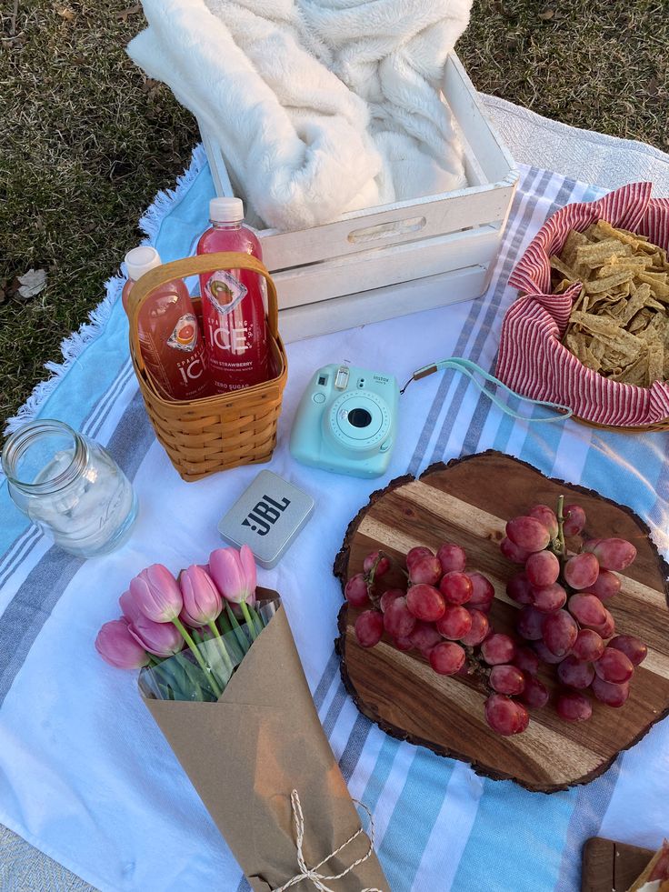 a picnic table with food and drinks on it, such as wine bottles, cookies, etc