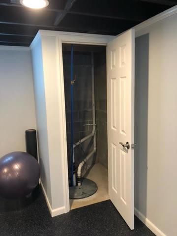 an exercise room with a ball and gym equipment in the corner, as well as a shower