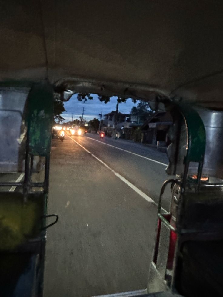 an old bus driving down the street at night