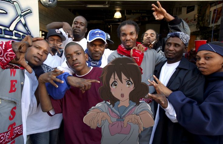 a group of people standing next to each other in front of a building with anime characters on it