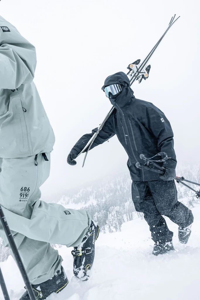 two skiers are walking in the snow with their skis on and holding poles