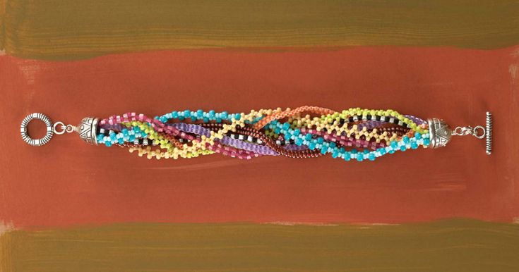 a beaded bracelet is displayed on a red surface