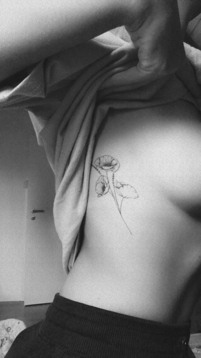 a woman with a flower tattoo on her lower back, showing it's blooming petals