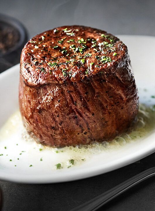 a piece of steak on a white plate