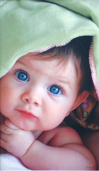 a black and white photo of a baby under a blanket