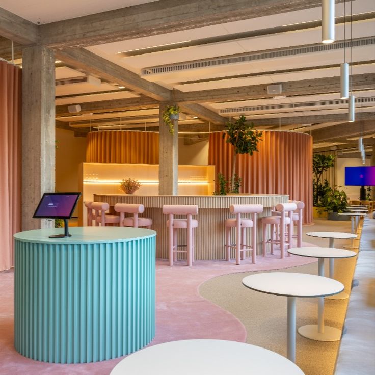 the interior of a restaurant with tables and stools