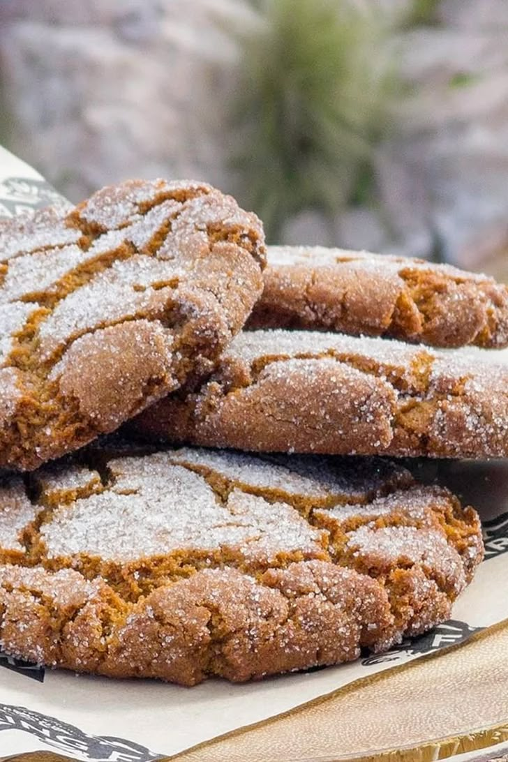 several cookies are stacked on top of each other with powdered sugar and sprinkles