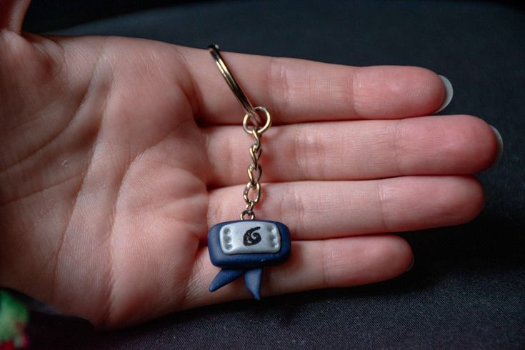 a hand holding a keychain with a cartoon character on it