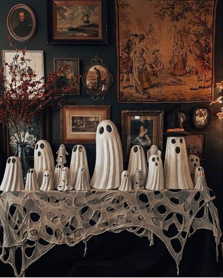 there are many ghost figurines on the table in front of pictures and paintings